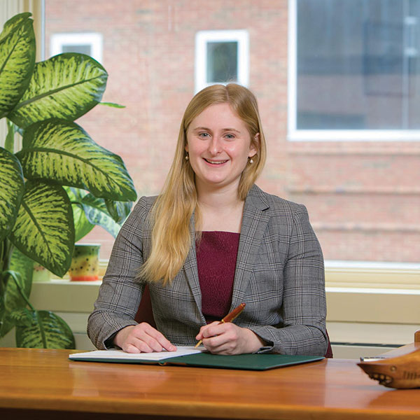 Mascoma bank employee smiling at camera while sitting behind large, cleared desk