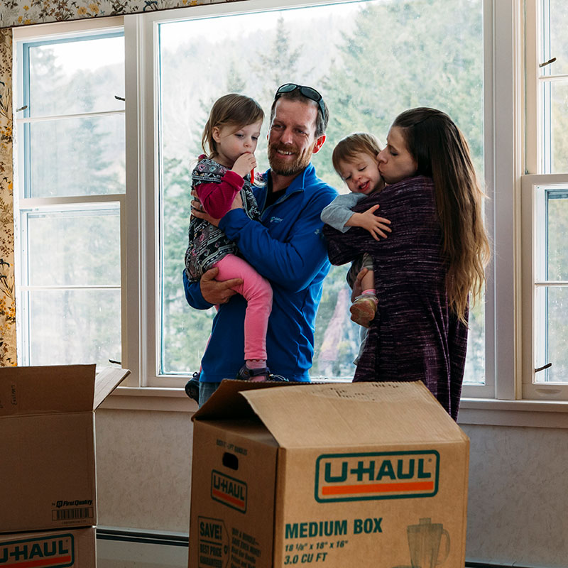 Family standing in new home after getting mortgage with Mascoma Bank