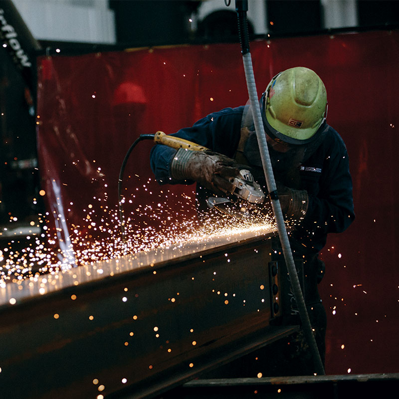 Steelworker at a local business grinding a weld on an steel beam