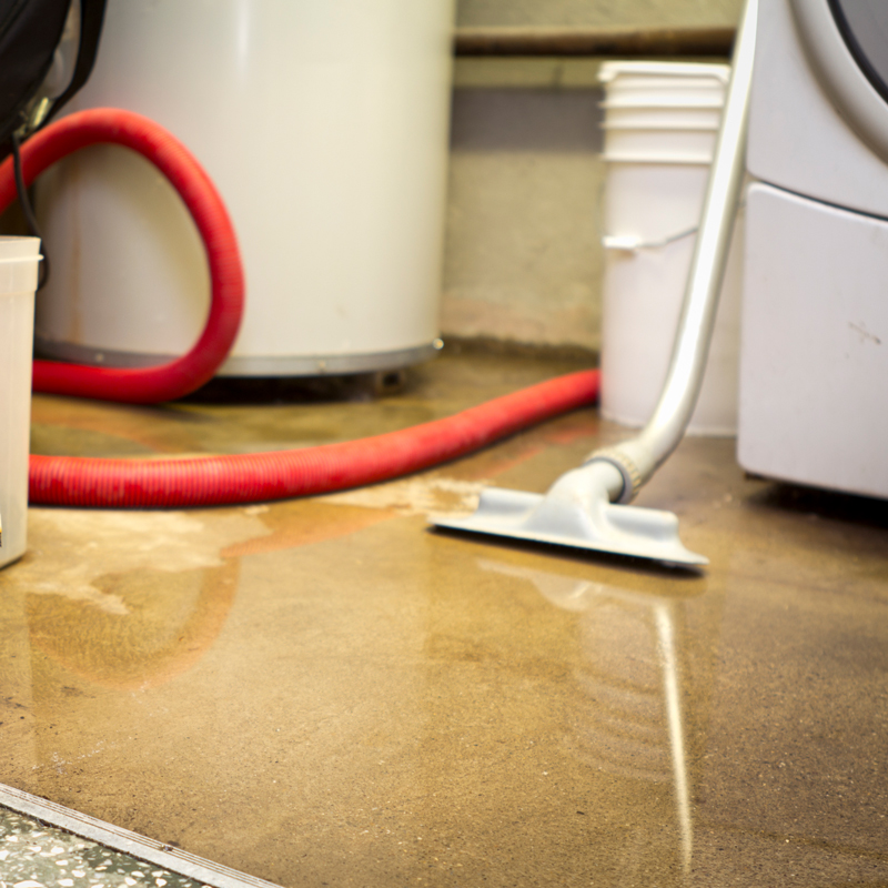 flooded basement showing a furnace, bucket, vaccum and washing machine