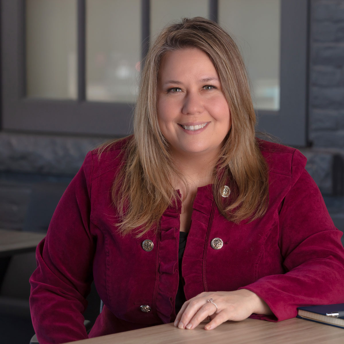 Joy Hastings with an inviting smiling while sitting at a desk